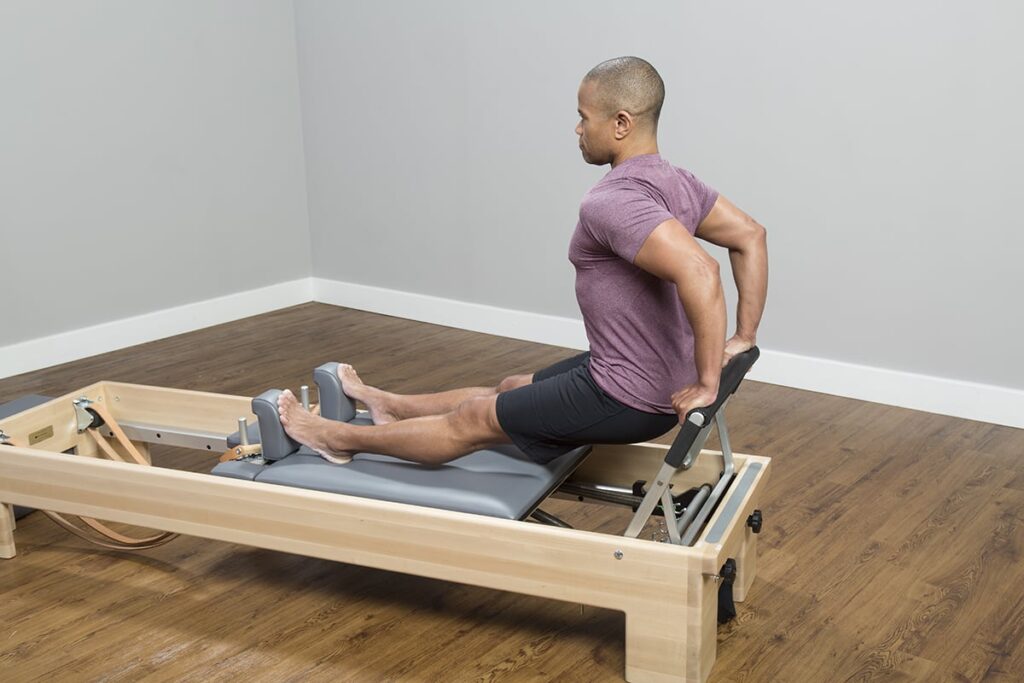 Person exercising on CenterLine Reformer for Pilates practice.