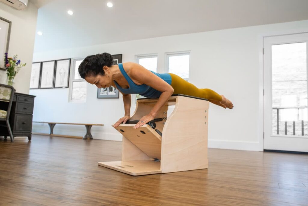 Instructor demonstrating exercise on Contrology Wunda Chair.