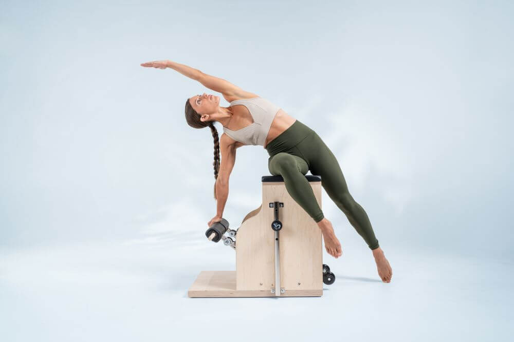 Pilates Combo Chair used for side stretch exercise.
