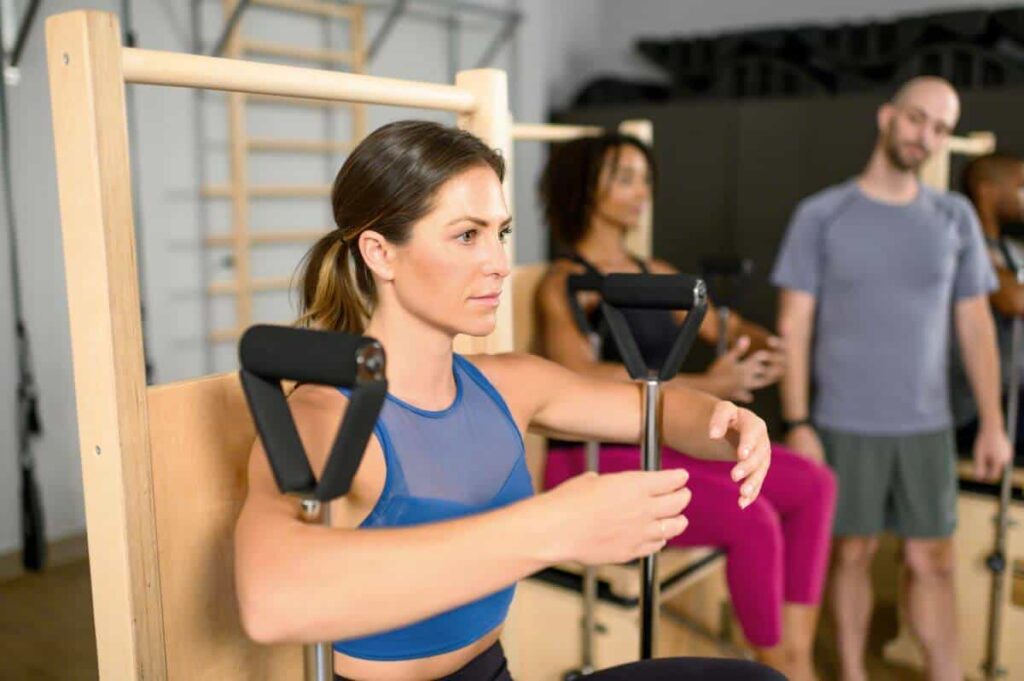 Профессионал использует тренажёр Wunda Chair от Balanced Body на занятии по пилатесу.