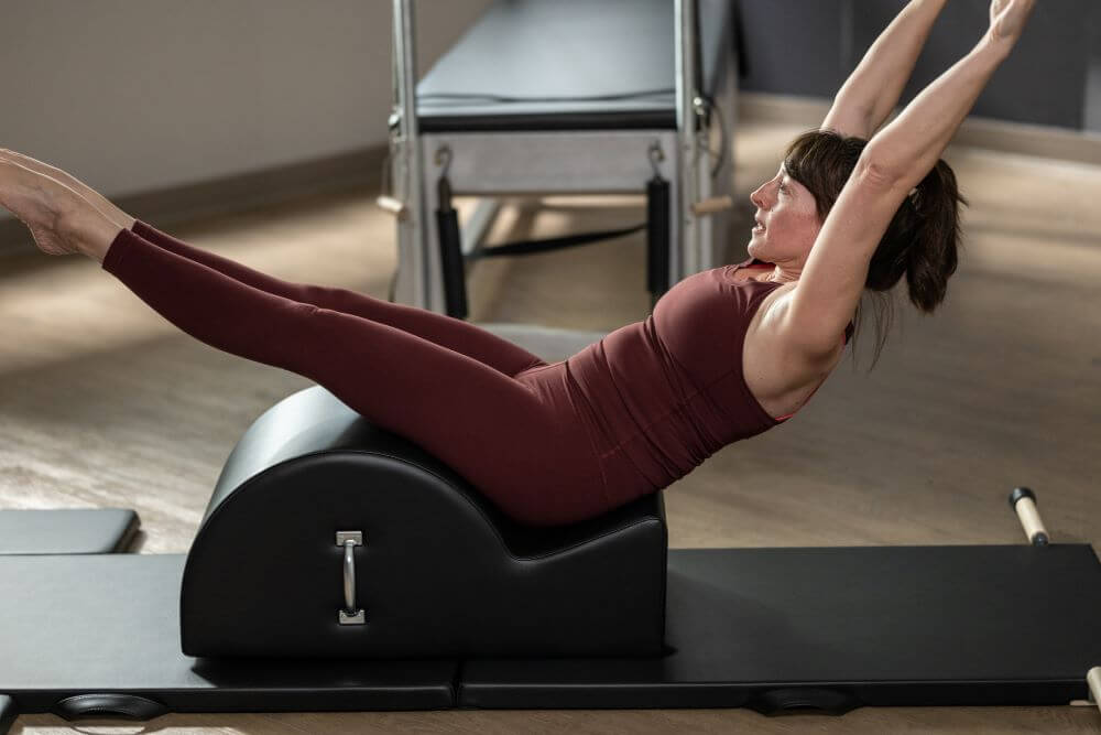 Женщина выполняет упражнения на корректоре позвоночника Contrology в студии.