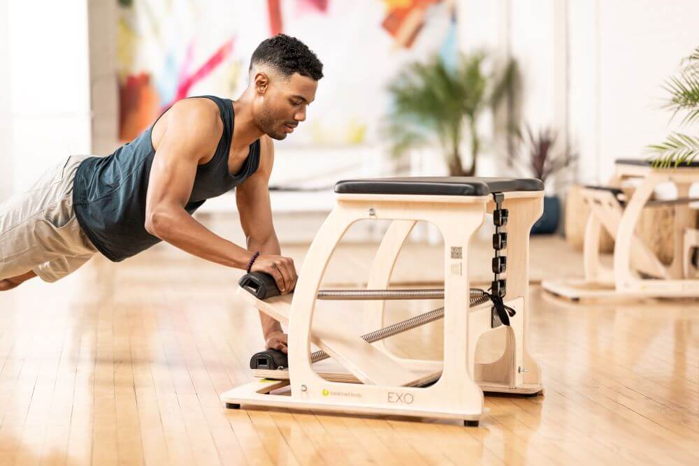 Мужчина занимается на тренажёре EXO Chair в студии.