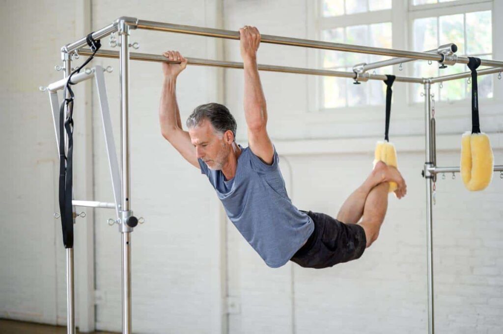Man using Pilates trapeze with Fuzzies for comfort and support.