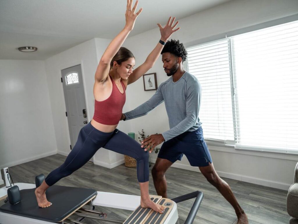 Instructor assists woman using Allegro 2 Standing Platform Extender.