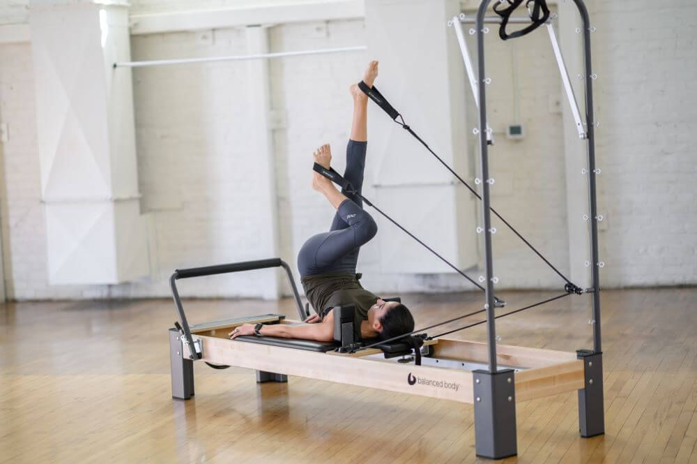 Person exercises on Rialto Reformer with Tower in studio