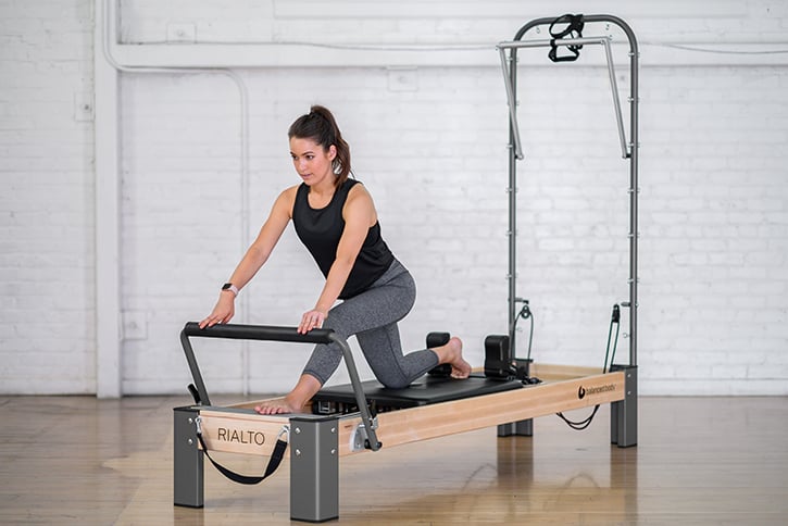 Rialto Reformer with Tower in use during Pilates workout
