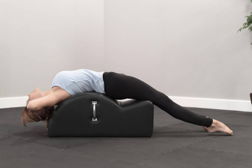 Person stretching on East Coast Step Barrel for Pilates exercise.