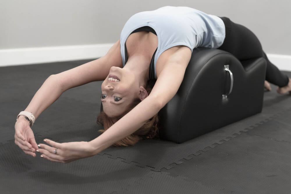 Person stretching on East Coast Step Barrel with integrated handles.
