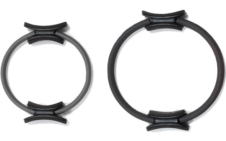 Du Pilates žiedai su paminkštintomis rankenomis, skirtingo dydžio ir pasipriešinimo.