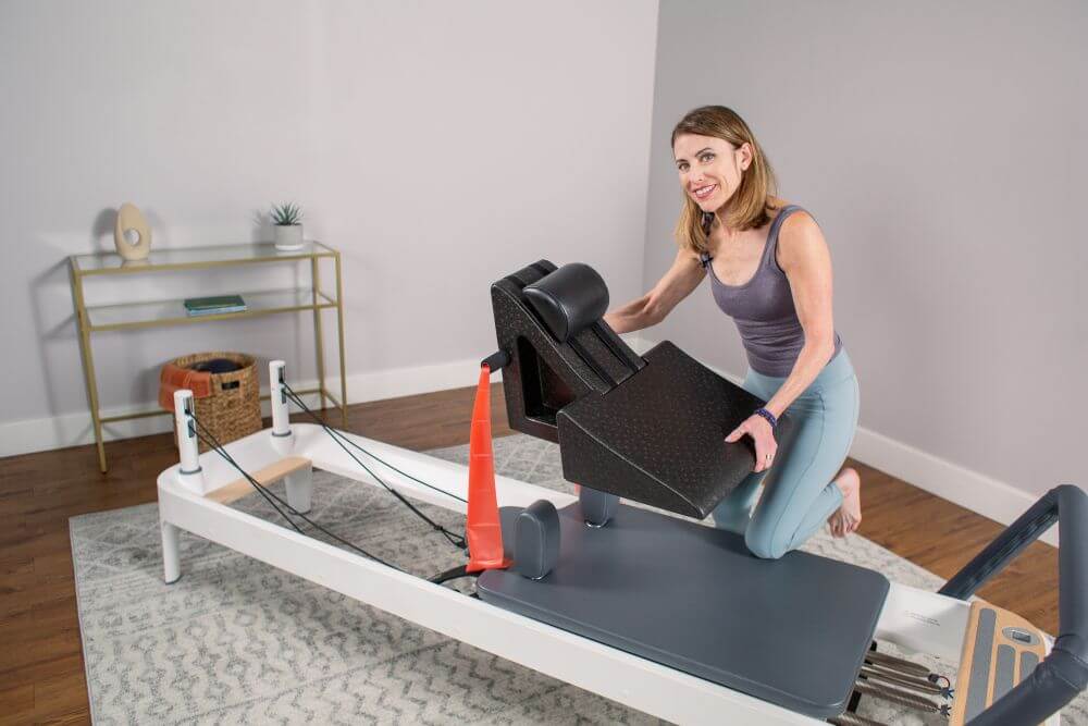 Woman demonstrating PilatesAngle on a Reformer.
