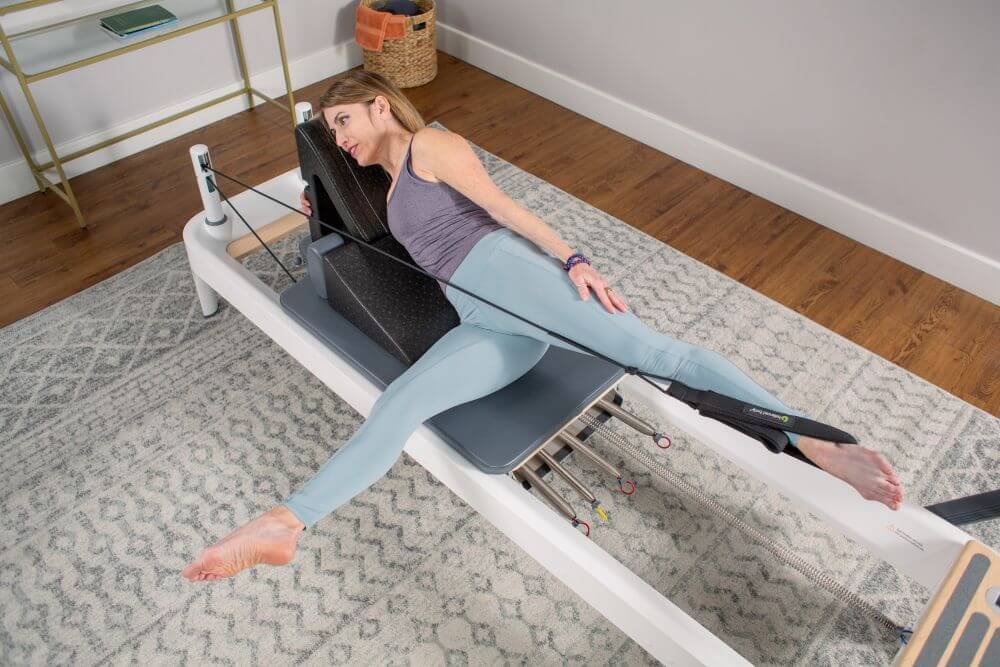 Person using PilatesAngle on Reformer for Pilates exercise.