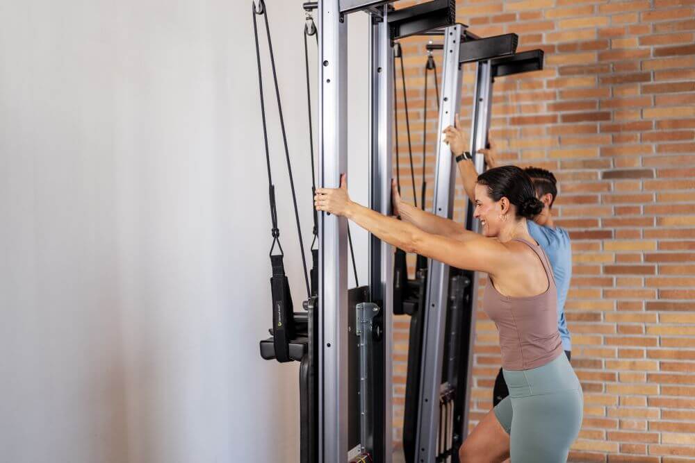 Du asmenys naudoja Allegro Nextgen Reformerius Pilates studijoje.